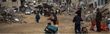 Displaced people carrying their belongings through the rubble of destroyed houses in Khan Younis, in the southern Gaza Strip, as they seek refuge. Photo: UNICEF/El Baba