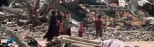 People amid a destroyed area in Khan Younis. Photo by OCHA, 17 April 2024