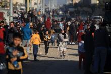 Displaced Palestinians walk while carrying water (Credit: Mohammed Zaanoun, 19 February 2024)